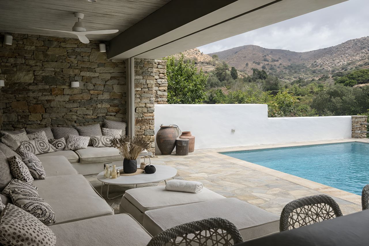 Outdoor lounge next to the pool with hillside views